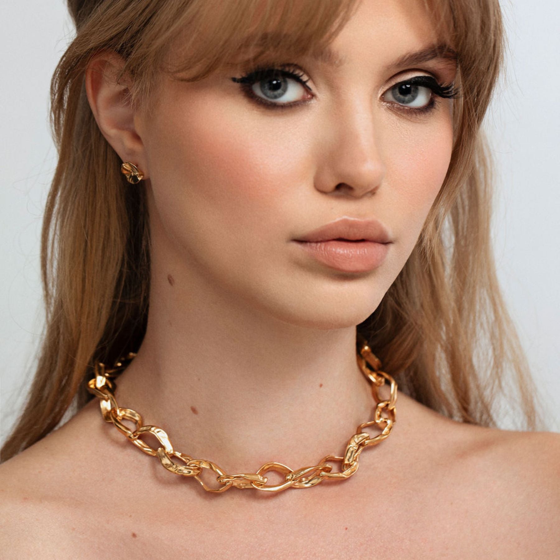 Woman wearing abstract chunky chain statement necklace in 14k yellow gold by Jessica Liu