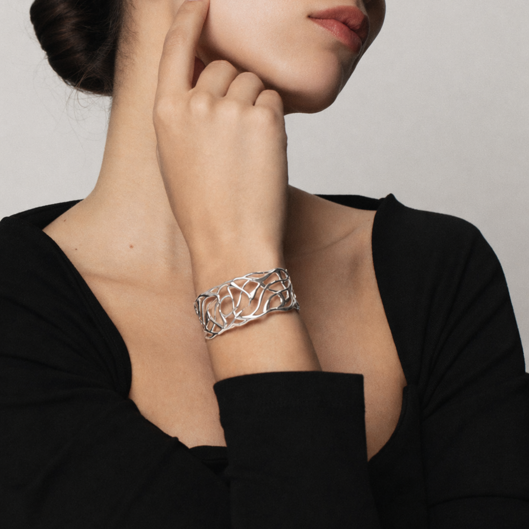 model's wrist showing artful fluid lines cuff bracelet in silver by jessica liu