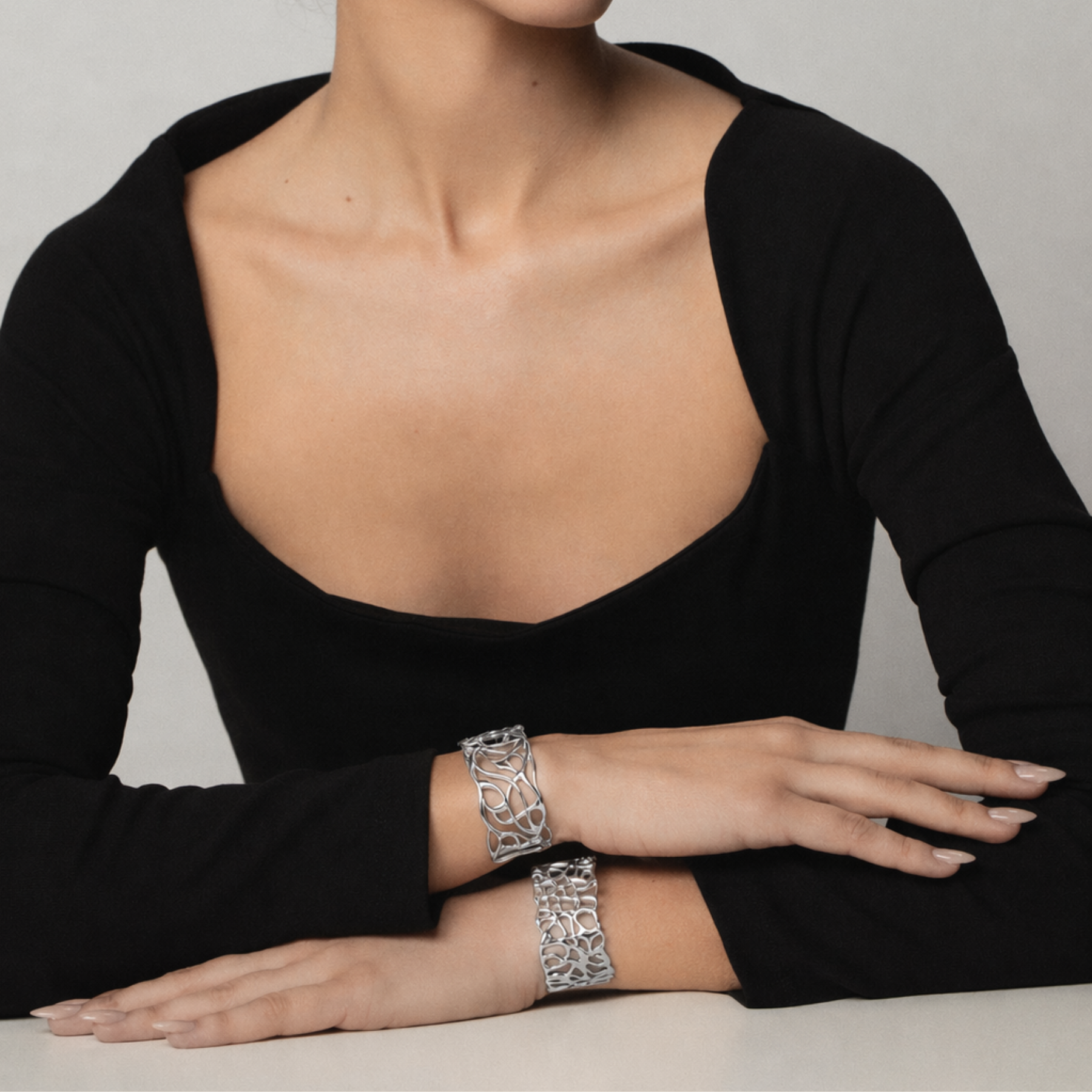 model's wrists showing organic and fluid coral cuff bracelet in silver and second silver cuff by jessica liu