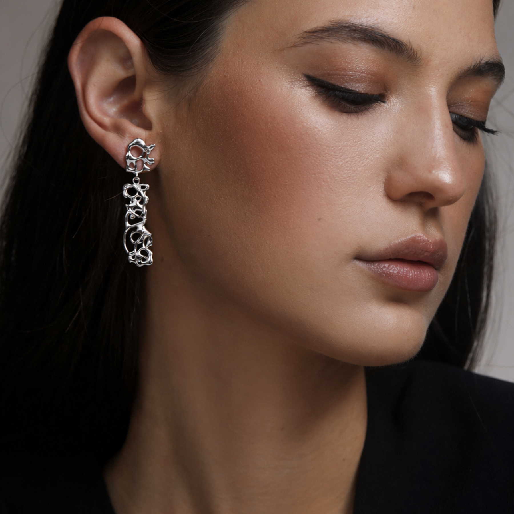 model wearing abstract squiggly dangling earrings in silver by jessica liu