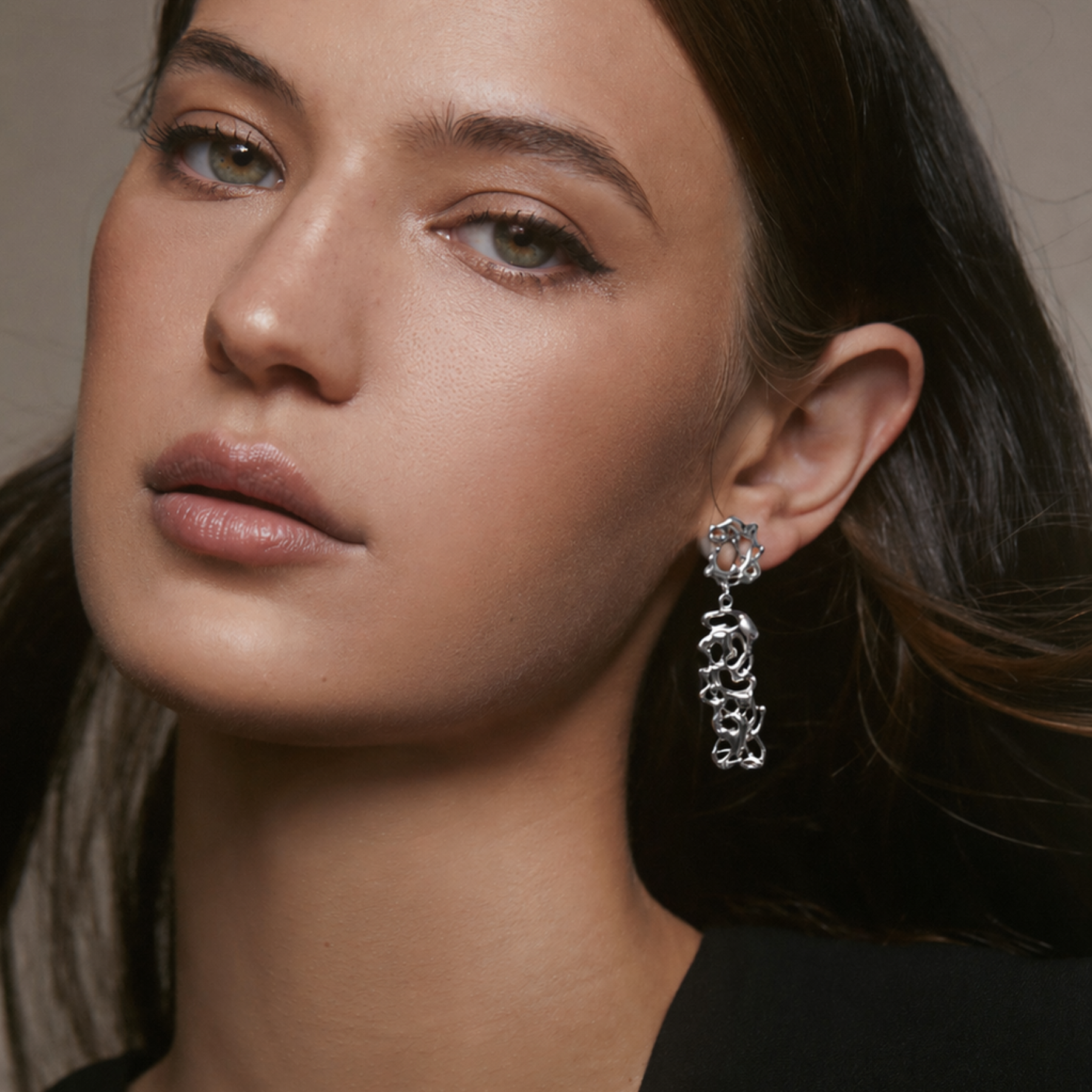model wearing abstract squiggly dangling earrings in silver by jessica liu