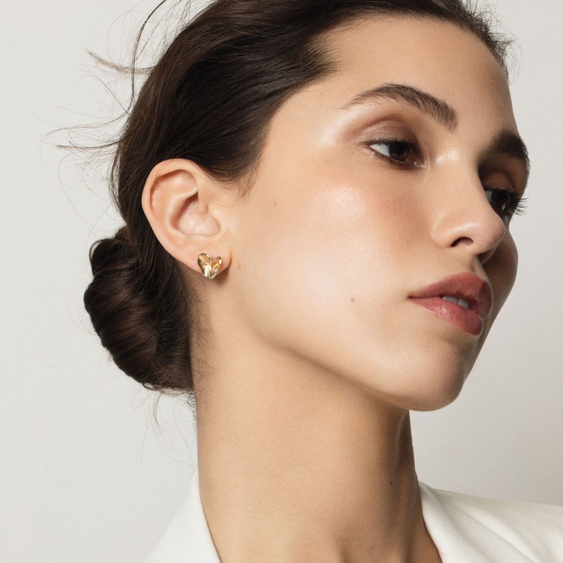 folded origami heart stud earrings in 14k gold on model by jessica liu 