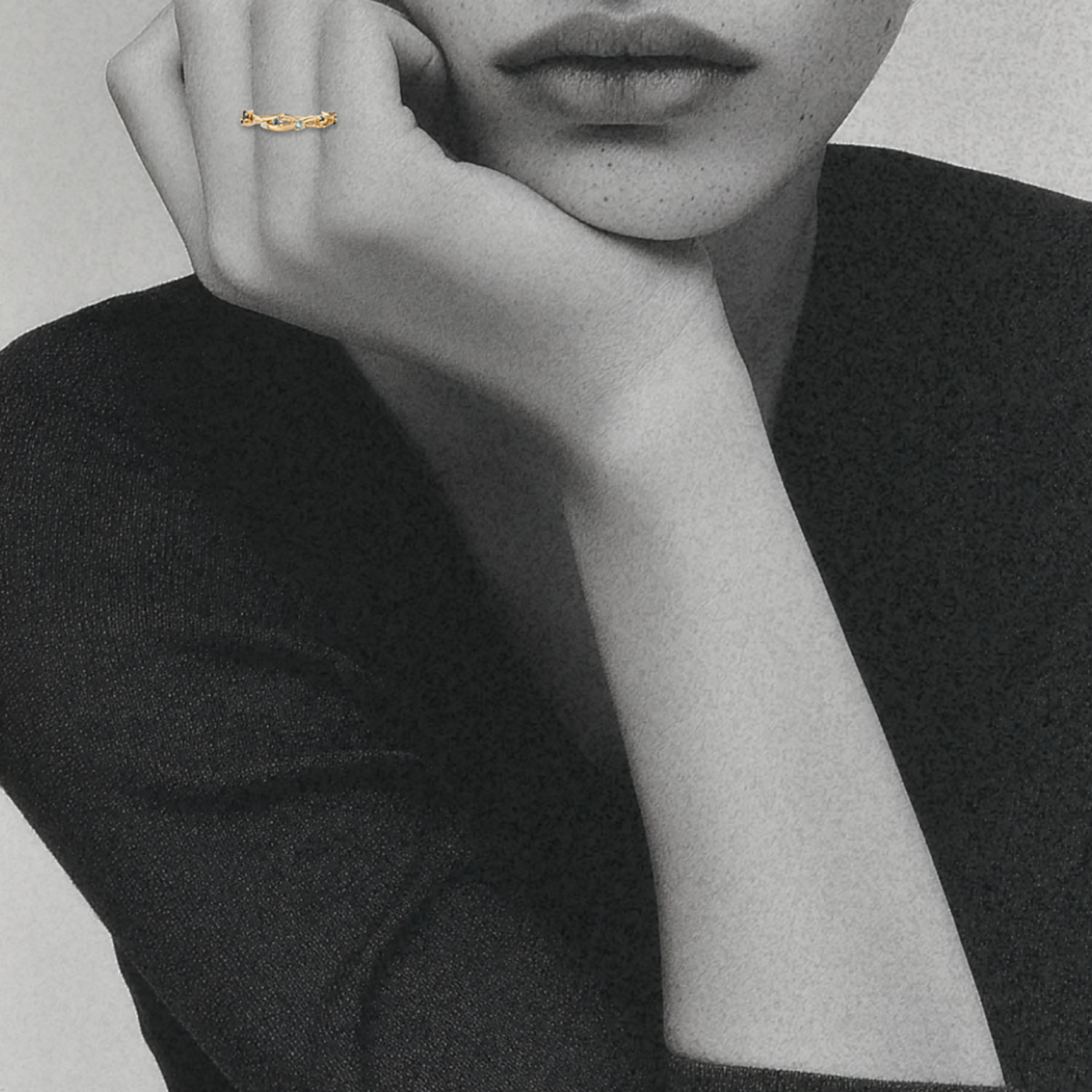 model's hand wearing organic interweaving ring band with blue gemstones by jessica liu