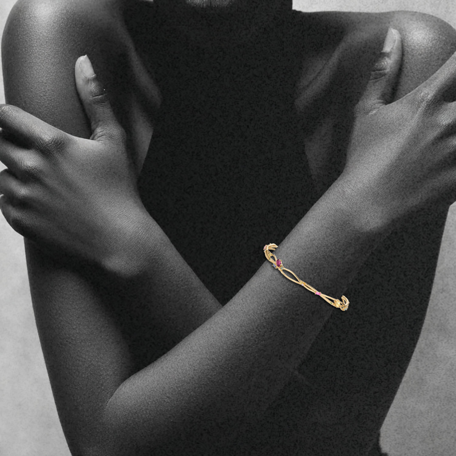 model wearing organic interweaving bangle in 14k gold with colored gemstones by jessica liu