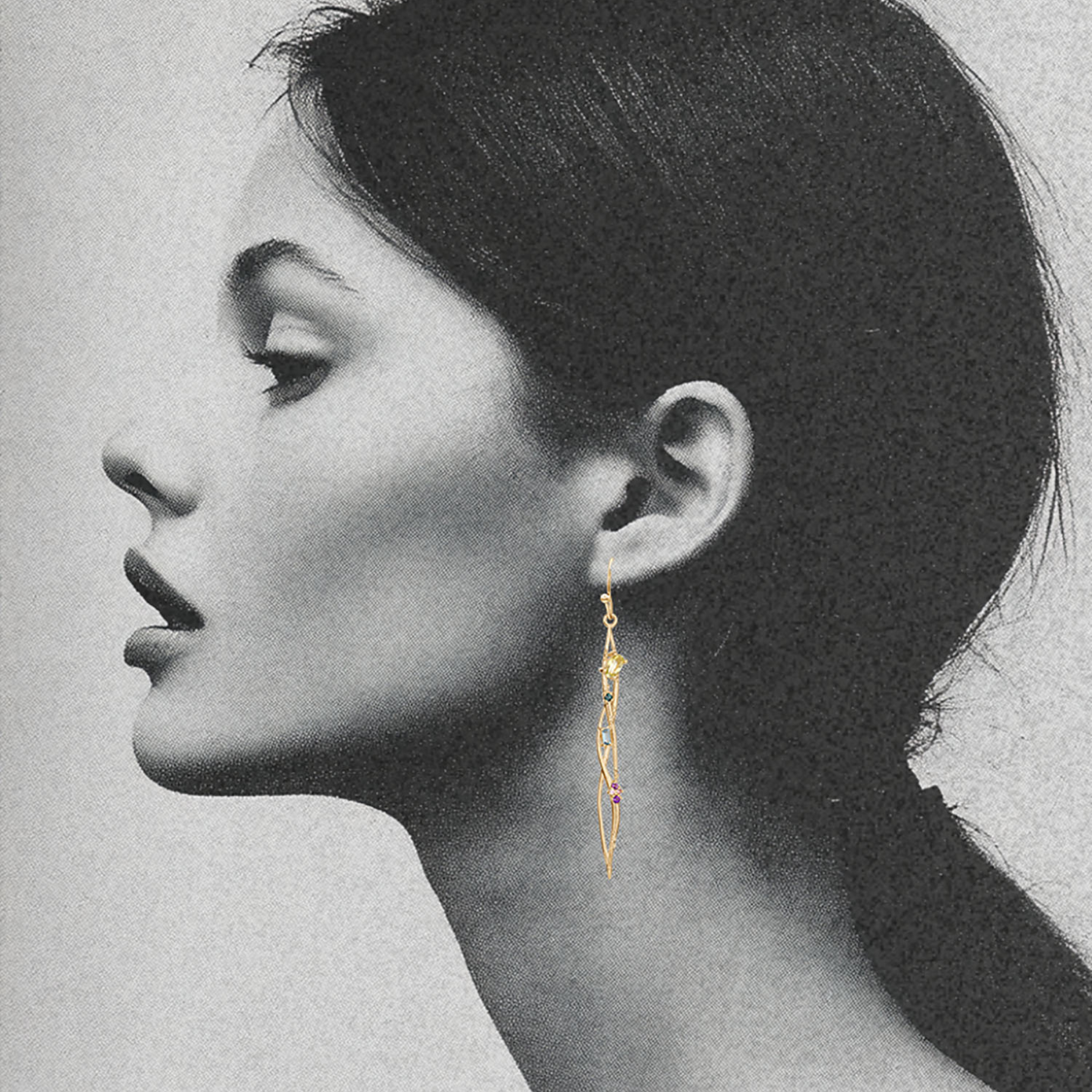 woman wearing organic interweaving earrings in 14k gold with colorful gemstones by jessica liu