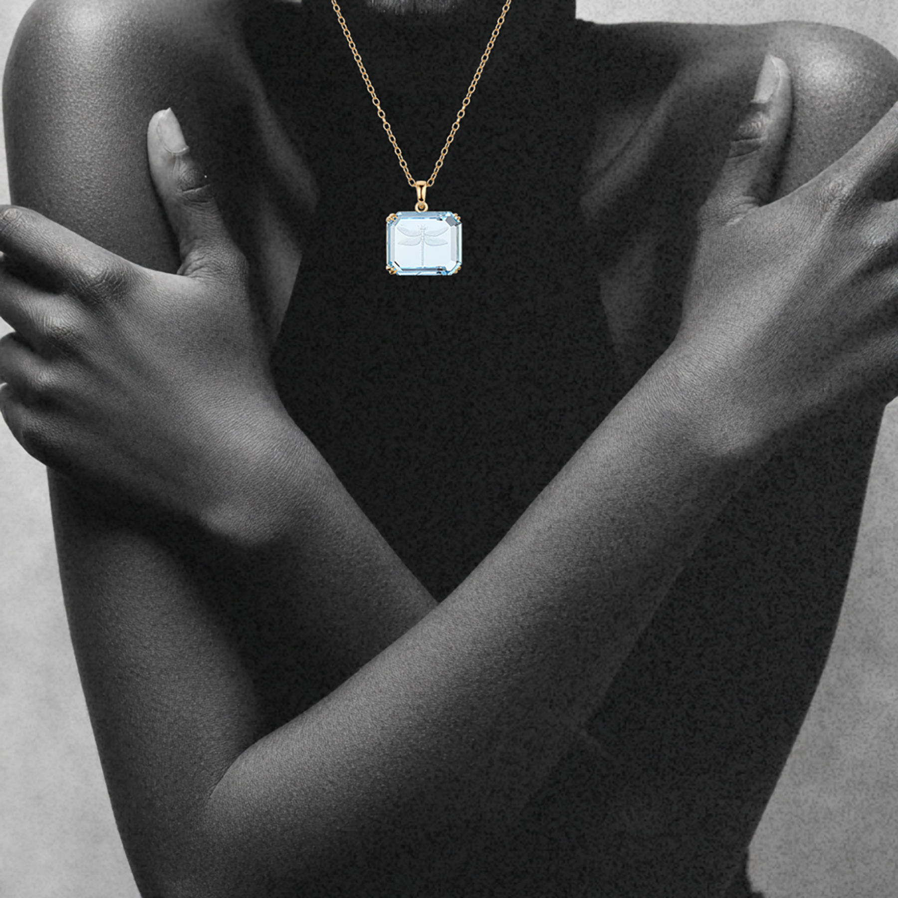 woman wearing dragonfly intaglio carving on a rectangular blue topaz pendant in 14k gold by jessica liu 