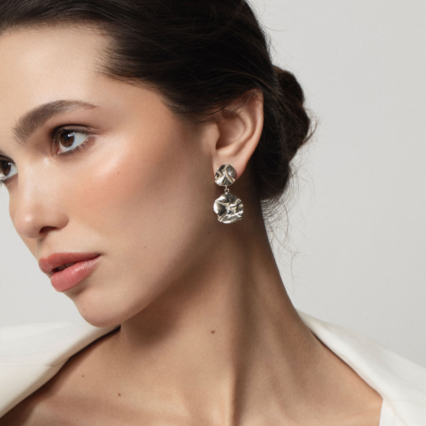 model wearing sculptural double lilypad dangling earrings in silver by jessica liu