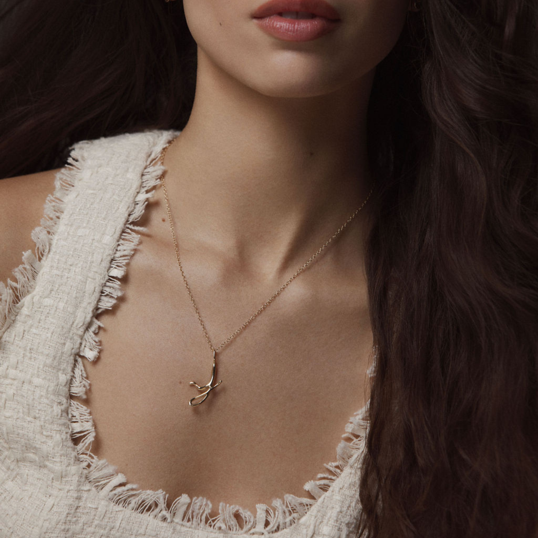 model wearing 14k gold letter j necklace by jessica liu