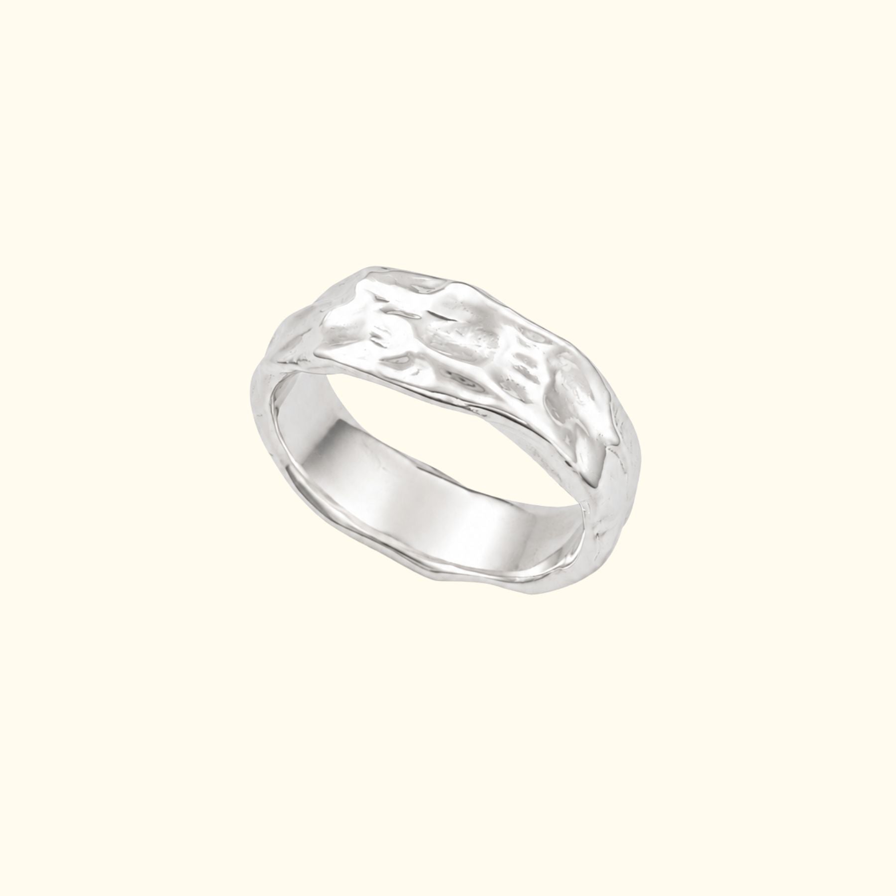 A textured sterling silver band ring by Jessica Liu with a polished, organic wavy surface, shown on a solid cream background.