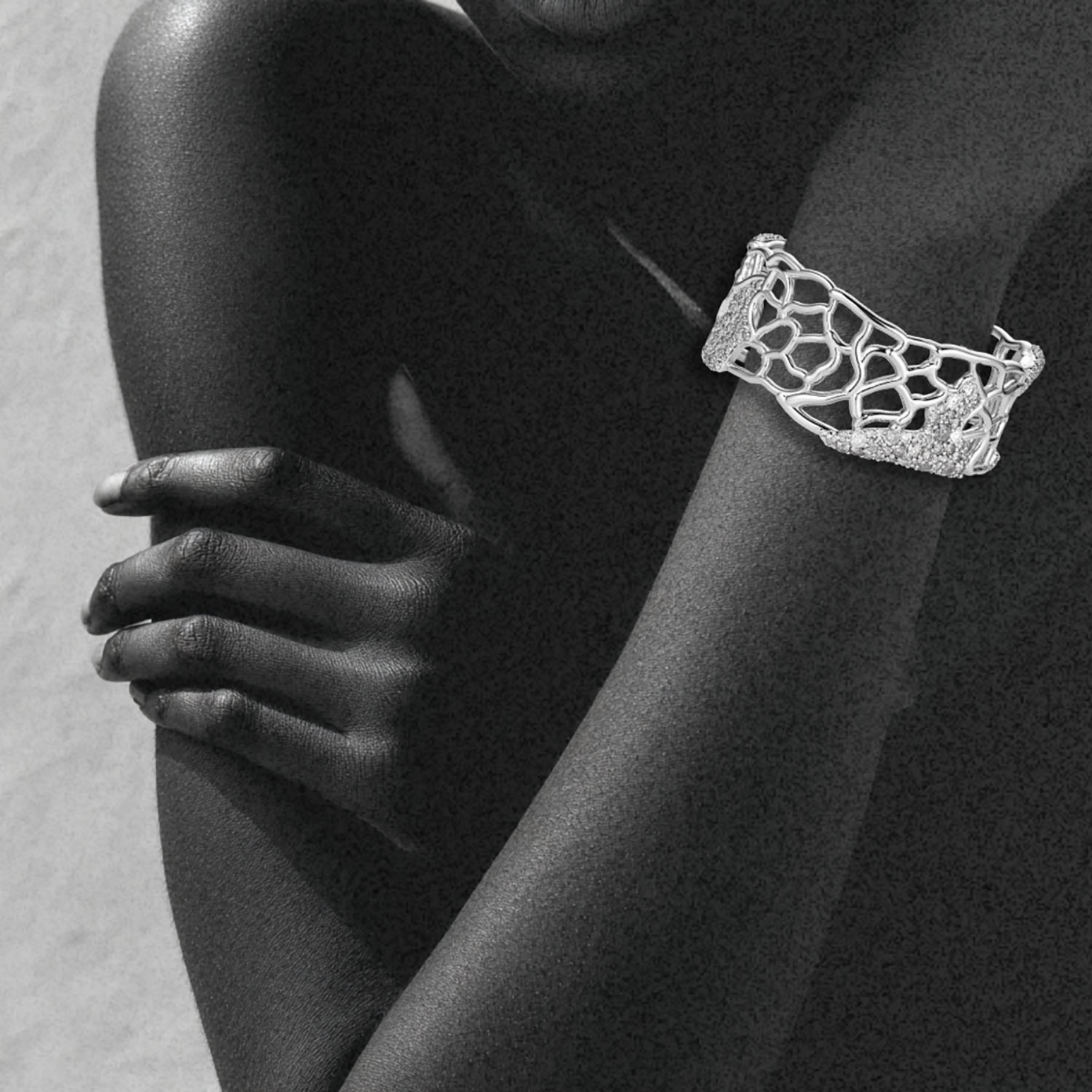 woman's wrist wearing organic abstract cuff bracelet in white gold with salt and pepper diamonds by jessica liu